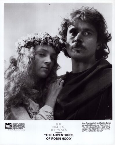 Black-and-white promotional photo of a man and a woman in medieval costumes, the woman wearing a flower crown, standing close together, with the title 'The Adventures of Robin Hood' at the bottom.