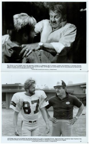 Black-and-white still from the film Against All Odds showing a tense scene as a man grips another's shoulder during a confrontation at a stadium setting. (informative still)