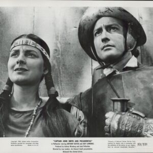 Black-and-white still of a Native American woman with braids and a man in armor, looking upward.