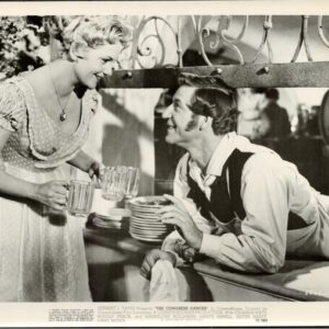 Vintage scene: woman in dress serves drinks to a man at a bar counter, smiling.