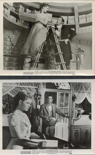 Two vintage film stills: a woman on a ladder holding boxes while a man in period costume speaks to her in a store set filled with shelves and gifts on both sides.