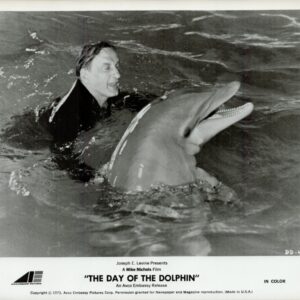 Black-and-white publicity photo of a man swimming in water with a dolphin, with the film title The Day of the Dolphin at the bottom.