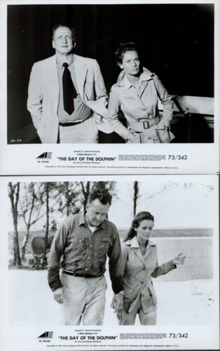 Promotional stills from The Day of the Dolphin: a man in a light suit and a woman in a trench coat pose together against a dark backdrop.