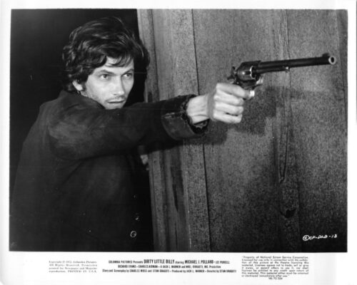 Man crouched behind a wall, aiming a revolver with a tense expression.