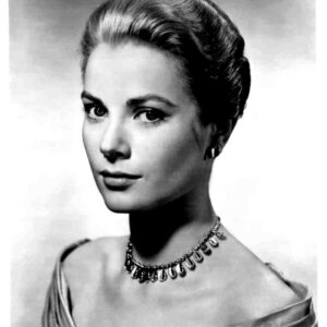 Black-and-white portrait of a young woman with an elegant updo hairstyle, wearing a teardrop necklace and off-shoulder gown.