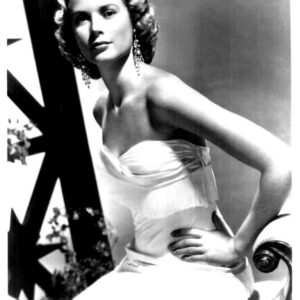 Vintage black-and-white portrait of a glamorous woman in a strapless gown and chandelier earrings, posed with one hand on her hip.