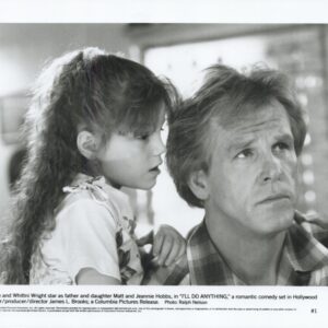 Black-and-white film still of a man and a young girl closely watching something off-camera, conveying a thoughtful moment between father and daughter in a family scene from I'll Do Anything.