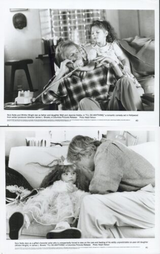 A father and young daughter sit on a couch; the father talks on a corded telephone while the girl reaches toward him with her hand on his.