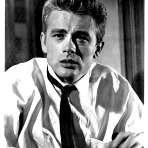 Black-and-white portrait of a young man in a white shirt and dark tie, looking slightly to the side with a serious expression.