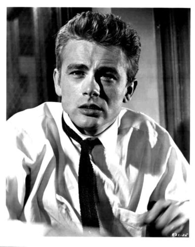 Black-and-white portrait of a young man in a white shirt and dark tie, looking slightly to the side with a serious expression.
