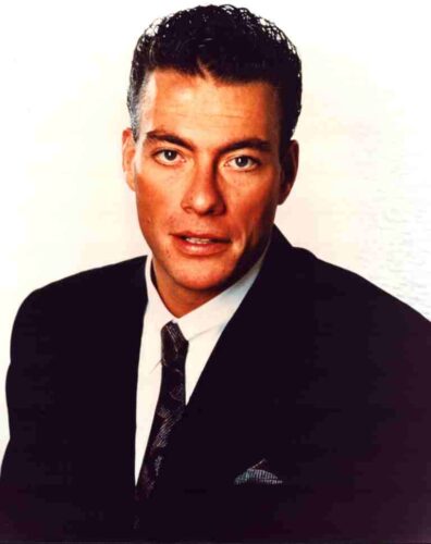 Formal head-and-shoulders portrait of a man in a dark suit and tie, looking at the camera against a light background.