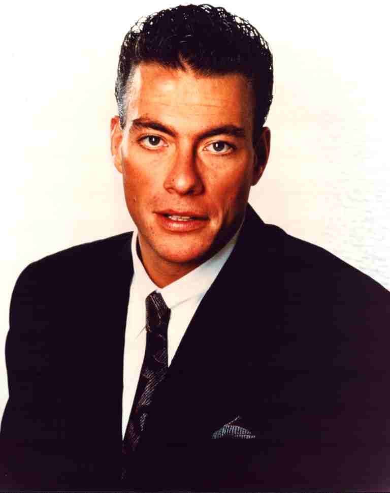 Formal head-and-shoulders portrait of a man in a dark suit and tie, looking at the camera against a light background.