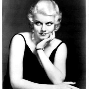 Black-and-white portrait of a glamorous woman in a black evening dress, resting her chin on her hand.