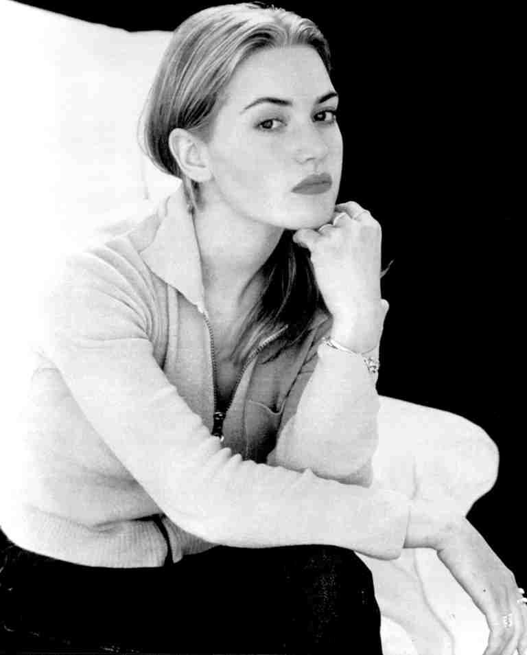 Black-and-white portrait of a woman resting her chin on her hand, wearing a light sweater.