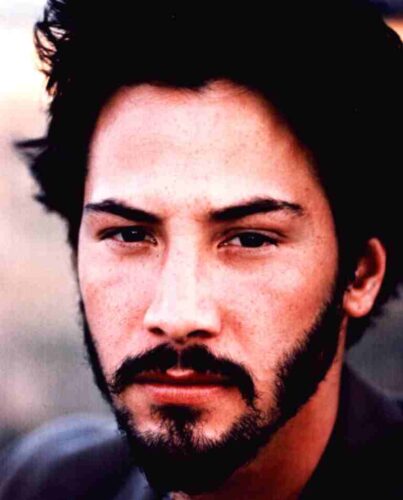 Close-up portrait of a man with dark hair and a beard, looking intently at the camera.