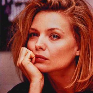 Close-up of a woman with blonde hair resting her chin on her hand, looking thoughtful.
