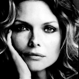 Close-up black-and-white portrait of a woman resting her cheek on her hand.