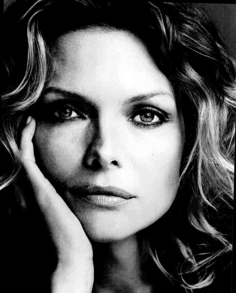 Close-up black-and-white portrait of a woman resting her cheek on her hand.