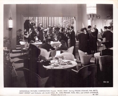 A vintage hotel lounge scene with a big-band on stage and couples dancing, tables set for dining in the foreground.