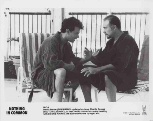Two men in bathrobes sit on poolside chairs, gesturing as they talk in a black-and-white still from the 1986 film Nothing in Common.