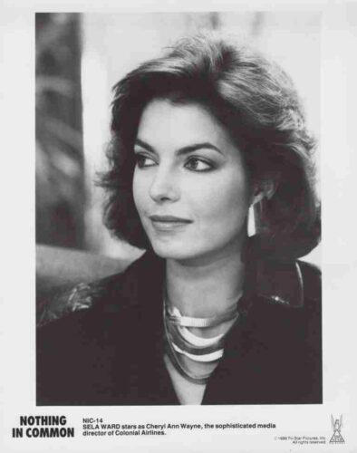 Black-and-white publicity photo of actress Sela Ward as Cheryl Ann Wayne in Nothing in Common, looking to the side, wearing a multi-strand necklace; caption notes she’s the media director of Colonial Airlines.