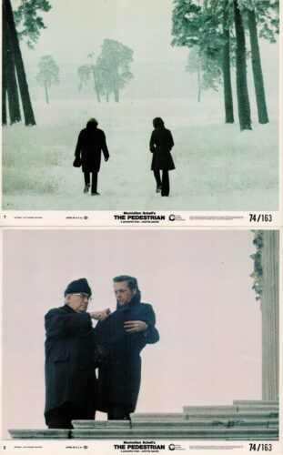 Two people walk away through a snowy, tree-lined field in winter. (top panel)