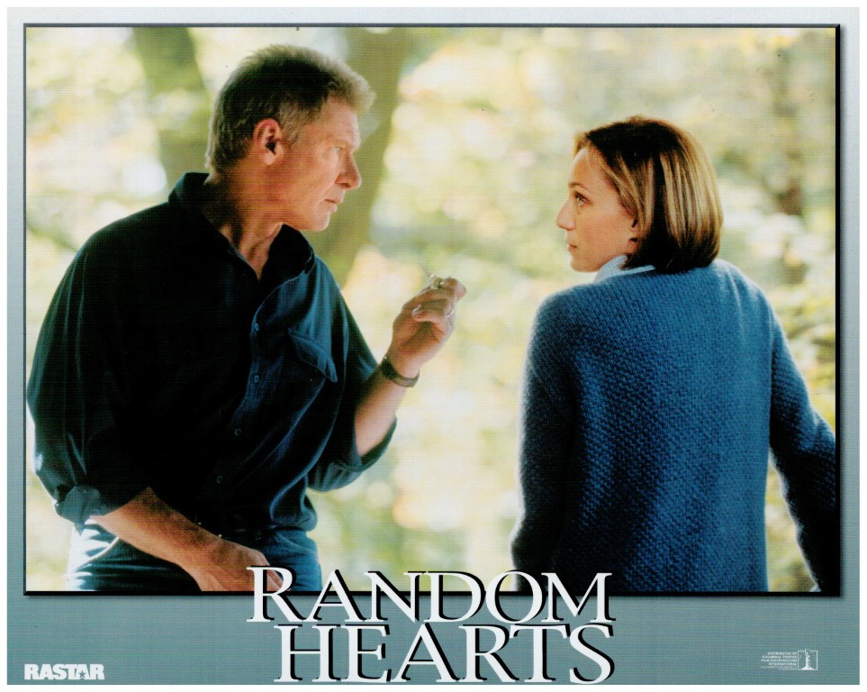 Movie poster: man in dark shirt and woman in a blue sweater face each other; 'Random Hearts' title across bottom.