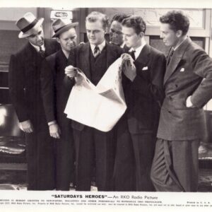 Six men in 1930s suits gather around a large newspaper, reading it together in a studio-like room.