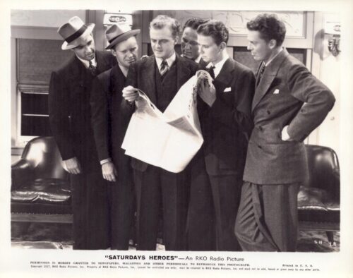 Six men in 1930s suits gather around a large newspaper, reading it together in a studio-like room.