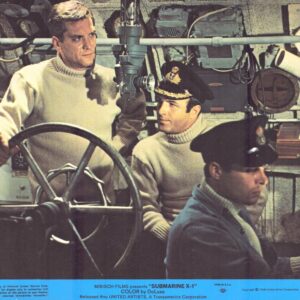 Three sailors in a submarine control room around a large wheel, focused on their tasks in knit sweaters and caps.