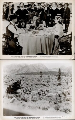 Banquet scene with a king or noble at a round table, flanked by two seated guests in period dress as attendants stand behind in a formal, cinematic setting.