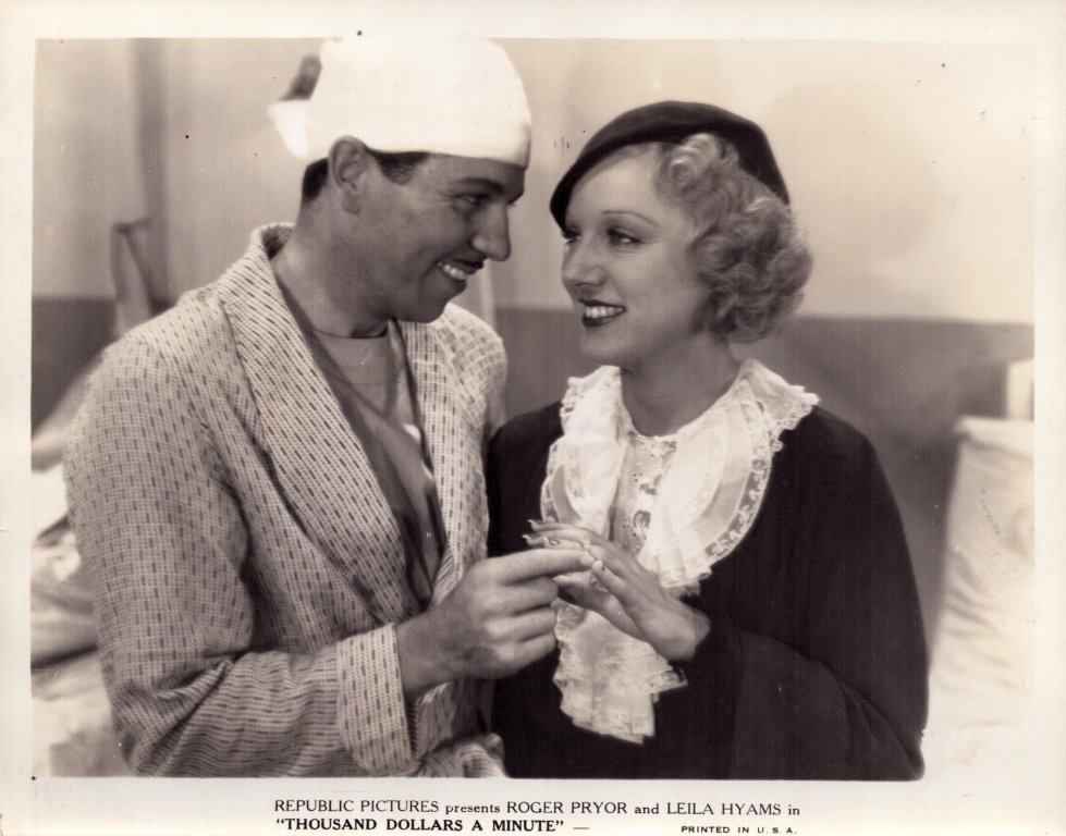 Vintage film still from Republic Pictures starring Roger Pryor and Leila Hyams: a man in a robe and a woman in period clothing share a smile while exchanging rings.