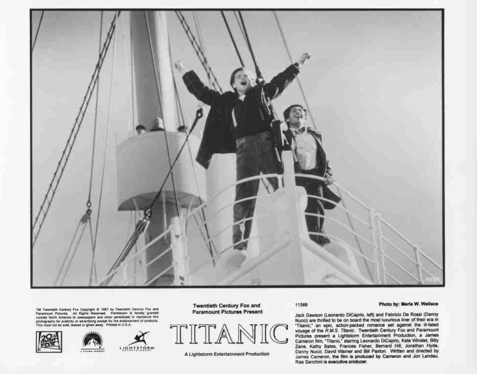 Black-and-white Titanic movie poster: three men stand on the bow of a ship with arms raised in celebration, celebrating at the front of the vessel.