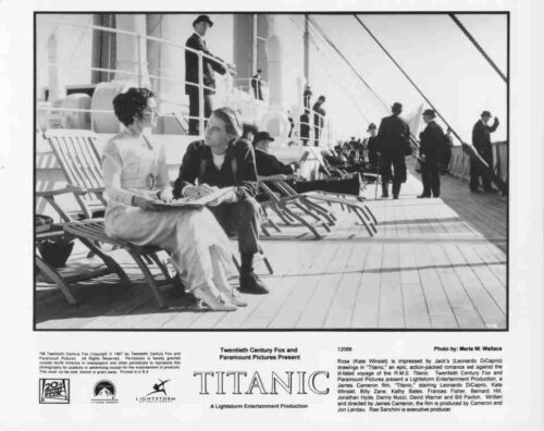 Black-and-white Titanic movie poster: two women sit and chat on a ship deck, with passengers walking in the background.