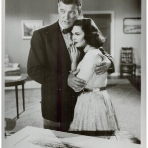 Black-and-white movie poster for Uranium Boom featuring a man and a woman embracing indoors; captioned with cast Dennis Morgan and Patricia Medina.