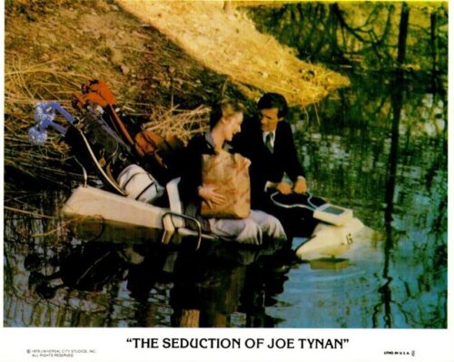 Movie poster for The Seduction of Joe Tynan featuring a man in a suit and a woman in a boat on water, with gear visible in the boat.