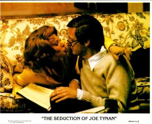 A man and woman kiss on a floral sofa, holding a script; promotional poster for The Seduction of Joe Tynan.