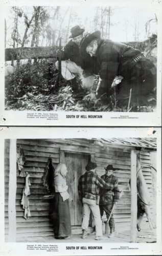Top frame: a man and woman crouch by a fence in the woods, inspecting something in the ground, a rifle resting nearby (South of Hell Mountain). Bottom frame: three people stand outside a rustic wooden shack, one man pointing while another leans on a stick, a game animal hangs nearby (South of Hell Mountain).