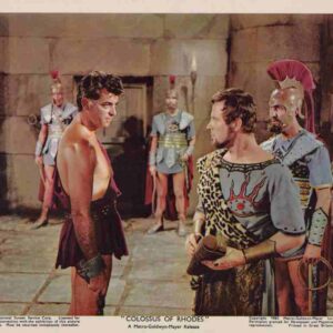 Two warriors face off in a stone arena as guards in armor observe from behind them at close range.