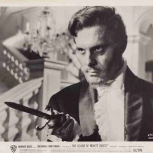 Promotional still from The Count of Monte Cristo: man in 19th-century attire brandishing a dagger with a dramatic stare.