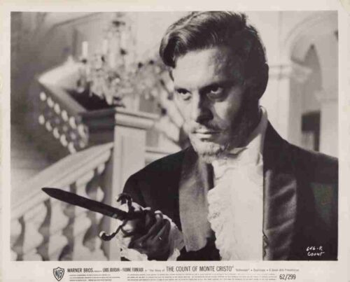 Promotional still from The Count of Monte Cristo: man in 19th-century attire brandishing a dagger with a dramatic stare.