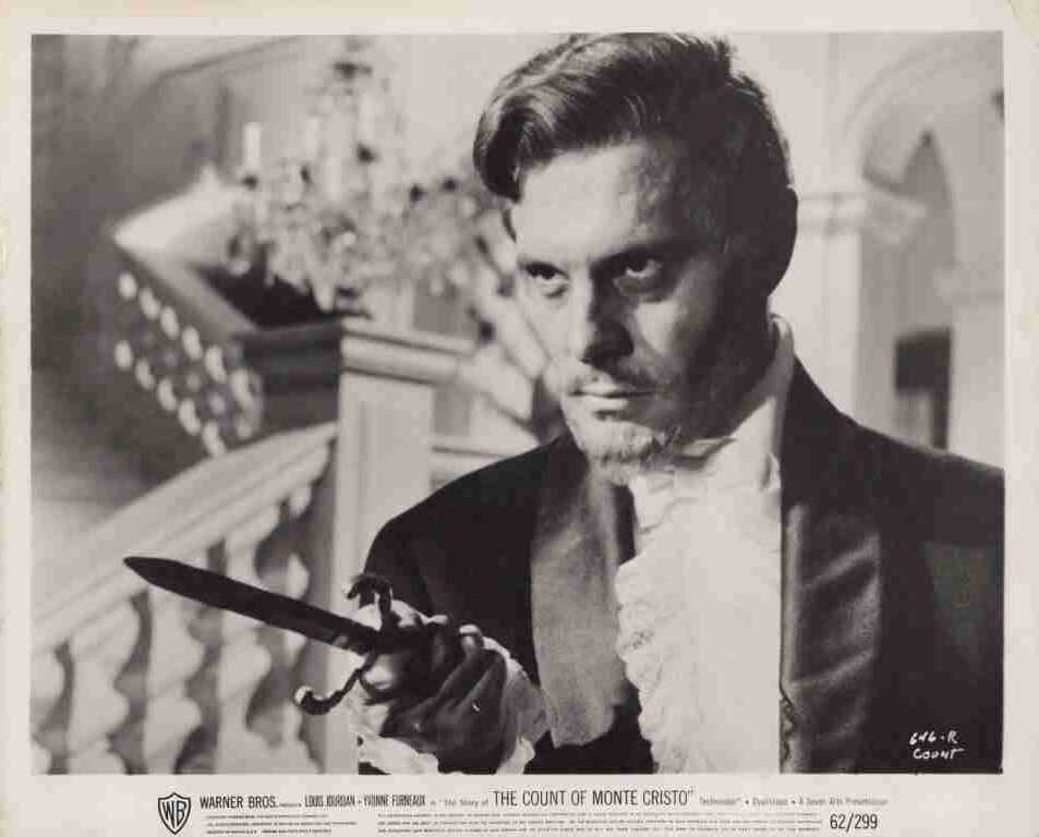 Promotional still from The Count of Monte Cristo: man in 19th-century attire brandishing a dagger with a dramatic stare.