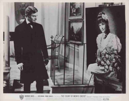 Man in a formal 19th-century suit stands in an art gallery, gazing at a portrait of a woman with flowers. (Movie poster for The Count of Monte Cristo)