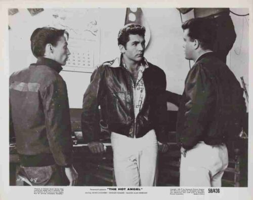 Three men in leather jackets stand in a room, facing each other; the center man looks toward the right, a film still from 'The Hot Angel'