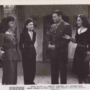 Four adults in vintage attire stand in a living room, with a man in a military uniform center, conversing with three women.