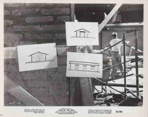 Construction site with wooden scaffolding and three hand-drawn house sketches pinned to a beam; a worker stands in the background.