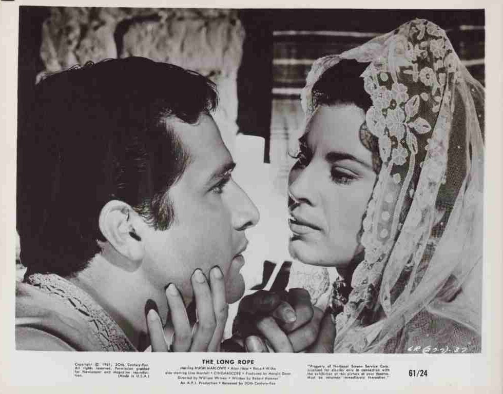 Man and bride gaze into each other's eyes; the bride wears a lace veil.